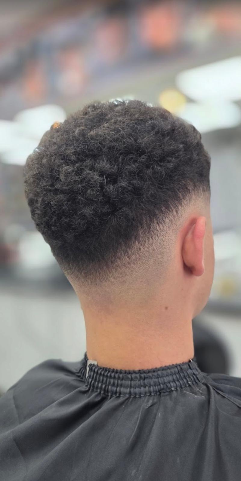 Curly top with a clean taper fade cut in Hull